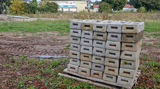 Ein Bild von Ende September: Das Baugelände ist vorbereitet. Bauzaunfüße stehen gestapelt auf dem Gelände.