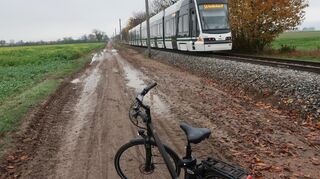 Matsch und tiefe Pfützen behindern Radfahrer auf dem Weg entlang der RNV-Linie 5a zwischen Heddesheim und Wallstadt