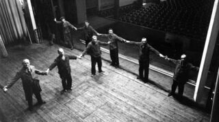 Bühnenarbeiter deuten die „Größe“ der Bühne im alten Kino an. Sie war nur vier Meter tief – winzig im Vergleich zu heutigen Dimensionen. Dennoch wurden hier auch große Wagner-Werke gegeben.