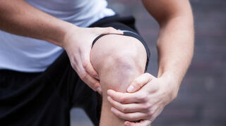 Ein Mann kontrolliert selbst die Stabilität seines Knies.