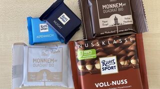 Der Hafersnack Monnemer Quadrat Bio von bleibwacker neben Tafeln von Ritter Sport.