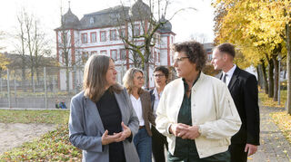 Schulleiterin Stephanie Liebers (l.) erklärt Regierungspräsidentin Sylvia M. Felder (vorne, weiße Jacke) die Aufgaben der Schlossschule.