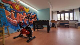 Im Wohnbereich des Internats gibt es auch eine selbst gestaltete Wand, Tischkicker, Sportgeräte und Musikinstrumente.