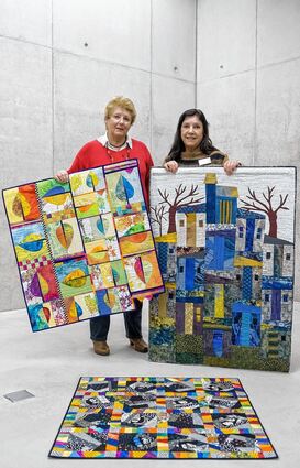 <p>Marita Brüggemann (links) hat diese Quilts für die Jubiläumsausstellung eingereicht, Mariette Kleinhans hilft beim Halten fürs Foto und hat eigene Werke.</p>